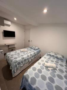 twee bedden naast elkaar in een kamer bij Manaira Suite 03 com 2 camas de solteiro ou 1 de casal in João Pessoa