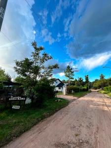 eine leere unbefestigte Straße mit einem Haus in der Ferne in der Unterkunft Aguila Blanca in Mina Clavero