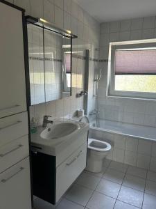 a white bathroom with a sink and a toilet at Daios in Wathlingen