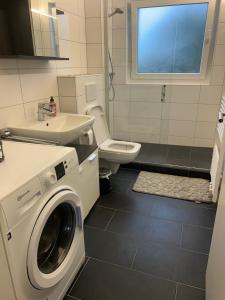 a bathroom with a washing machine and a toilet at Daios in Wathlingen