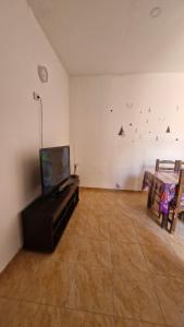 een woonkamer met een flatscreen-tv en een tafel bij Dpto 6 in La Cieneguita