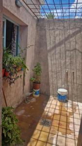 een terras met potplanten en een muur met een raam bij Dpto 6 in La Cieneguita