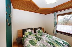 una camera con un letto e un piumone verde e bianco di Landhaus in den Weinbergen 