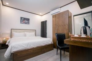 ein Schlafzimmer mit einem Bett und einem Schreibtisch mit Stuhl in der Unterkunft De Thaphae Chiangmai in Chiang Mai + 37 Fotos