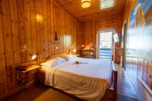 een slaapkamer met een bed in een houten kamer bij Villaggio Hotel Aquila in Calliano +101 foto's