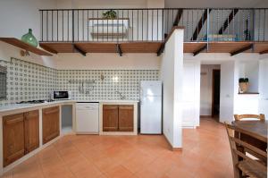 una cucina con mobili in legno e un frigorifero bianco di Villa Belvedere Amodeo - terrace, seaview, wifi a Conca dei Marini