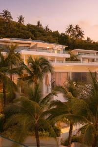 een gebouw met palmbomen ervoor bij The Seaview Kata in Kata Beach