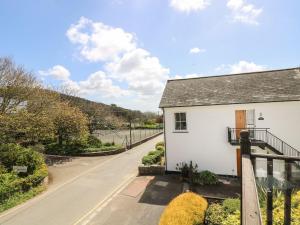 ein weißes Haus mit Balkon auf einer Straße in der Unterkunft Tater-Du in Porthcurno