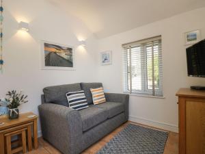 a living room with a couch and a window at Tater-Du in Porthcurno