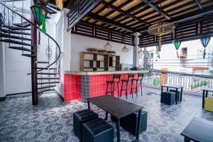 a restaurant with a bar with red counter and stools at De Thaphae Chiangmai in Chiang Mai