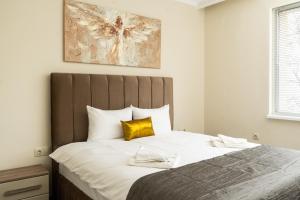 a bedroom with a large bed with a yellow pillow at Апартамент 8 in Lovech
