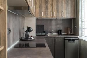 a kitchen with wooden cabinets and a sink at Апартамент 8 in Lovech +30 photos