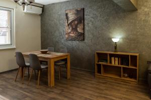 a dining room with a table and a book shelf at Апартамент 8 in Lovech