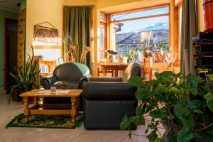uma sala de estar com duas cadeiras, uma mesa e uma janela em Hosteria Les Eclaireurs em Ushuaia