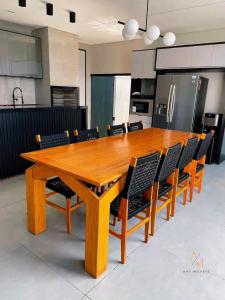 un tavolo in legno in una cucina con sedie intorno di Casa espaçosa e acolhedora a Ponta Porã