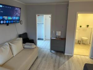 a living room with a white couch and a flat screen tv at 4-Bett-Appartement am Golfplatz in Grassau +18 photos