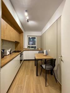 a kitchen with a wooden table and a dining room at Alegria Avantgarden Brasov in Braşov