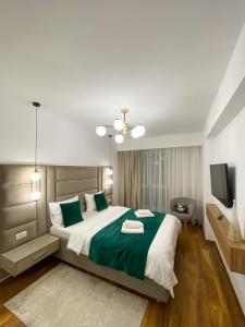 a bedroom with a large bed and a television at Alegria Avantgarden Brasov in Braşov