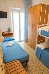 een slaapkamer met 2 bedden en een stapelbed bij Hotel Singapore in Milano Marittima +37 foto's