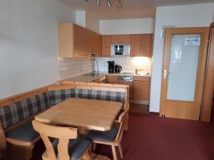 a small kitchen with a wooden table and chairs at Apartment Lyso en Soly in Königsleiten
