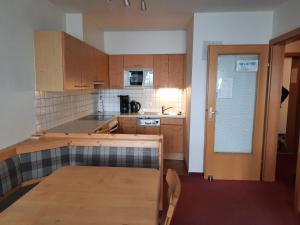 a kitchen with wooden cabinets and a wooden table at Apartment Lyso en Soly in Königsleiten +19 photos