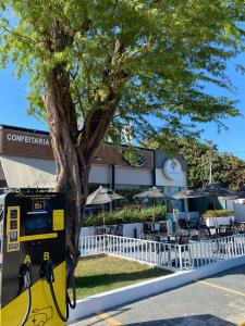 巴纳伊巴Pousada Primavera的餐厅门前有一棵树，旁边是一个停车计时器。