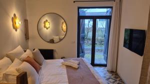 een slaapkamer met een groot bed en een spiegel bij Maison LAVIGNE in Blagnac