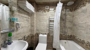 ein Badezimmer mit Badewanne, Toilette und Waschbecken in der Unterkunft Sheki Central Apartment Deluxe in Şəki + 8 Fotos