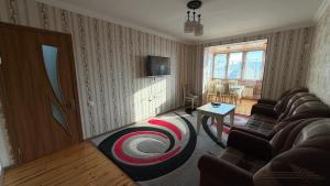 ein Wohnzimmer mit Sofa und Tisch in der Unterkunft Sheki Central Apartment Deluxe in Şəki
