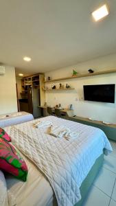 een slaapkamer met een groot bed en een flatscreen-tv bij Malia Beach Experience - Muro Alto/PE in Cupe