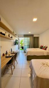 een hotelkamer met twee bedden en een tafel en stoelen bij Malia Beach Experience - Muro Alto/PE in Cupe
