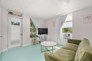 ein Wohnzimmer mit Sofa und Tisch in der Unterkunft Sebring Circle Studio Stay- Postcard Mural Views in Sebring