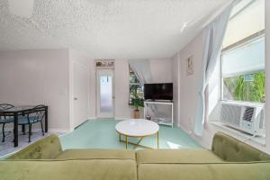 ein Wohnzimmer mit Sofa und Tisch in der Unterkunft Sebring Circle Studio Stay- Postcard Mural Views in Sebring