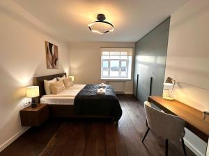 a bedroom with a bed and a desk and a window at Panoramic River View I Spacious Modern 2BR Apartment in Riga