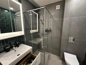 a bathroom with a shower and a sink at Panoramic River View I Spacious Modern 2BR Apartment in Riga