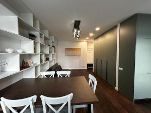 a dining room with a table and white chairs at Panoramic River View I Spacious Modern 2BR Apartment in Riga