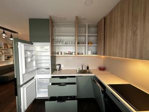 a kitchen with a sink and an open refrigerator at Panoramic River View I Spacious Modern 2BR Apartment in Riga +37 photos