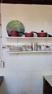 una mensola in una cucina con pentole e padelle di Pousada Três Irmãos a Parati