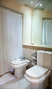 een badkamer met een toilet, een wastafel en een spiegel bij Portezuelo Hotel in Salta