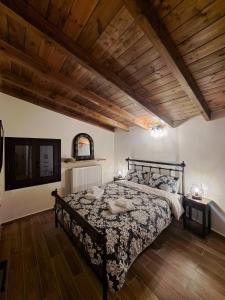 una camera da letto con un letto e un soffitto in legno di Αυγήλιον - Private Mountain House a Synikia Mesi Trikalon