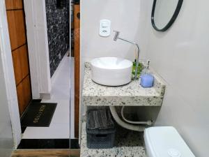 a bathroom with a sink and a toilet at Flat confortavel e aconchegante in Cabo Frio