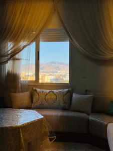 a living room with a couch and a large window at Afalux Brand chic in Agadir