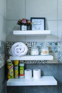 a bathroom shelf with toilet paper and towels at Mivida Residences in Bulindo +2 photos