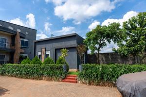 a gray house with a brick driveway at Mivida Residences in Bulindo