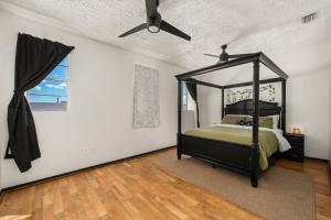 a bedroom with a canopy bed and a window at Circle Overlook-Downtown Apartment Stay in Sebring