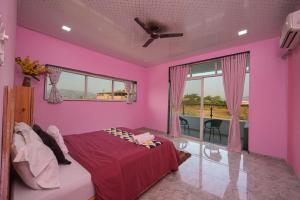 een roze slaapkamer met een bed en een raam bij ll EMPYREAN STAY ll BIG DADDY VILLA ll 6BHK ll AC ll PRIVATE POOL ll BACHELORS FRIENDLY ll in Malavli +47 foto's