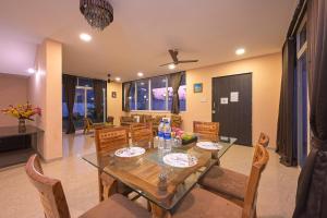 een eetkamer met een houten tafel en stoelen bij ll EMPYREAN STAY ll BIG DADDY VILLA ll 6BHK ll AC ll PRIVATE POOL ll BACHELORS FRIENDLY ll in Malavli