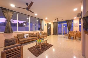 een woonkamer met een bank en een tafel bij ll EMPYREAN STAY ll BIG DADDY VILLA ll 6BHK ll AC ll PRIVATE POOL ll BACHELORS FRIENDLY ll in Malavli