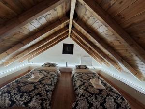 2 letti in una camera mansardata con soffitti in legno di Αυγήλιον - Private Mountain House a Synikia Mesi Trikalon