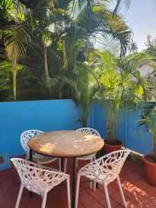 a table and chairs on a patio with palm trees at Florin Studio in Vagator